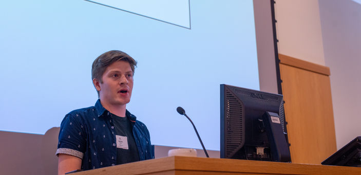 a BSU student stands at a podium giving a presentation