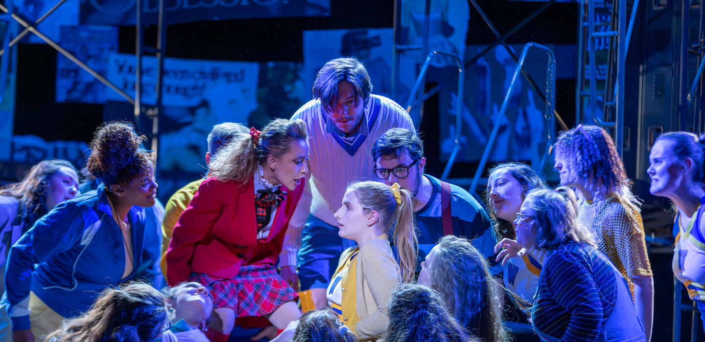 a scene from the play Heathers at BSU where a group of people appear to be taunting a girl in the spotlight