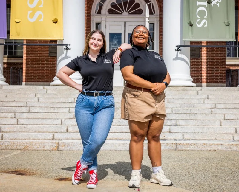 Two students posing outside campus