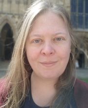 Dr. Kyla Bender-Baird with long straight dirty blonde hair wearing a black and maroon top