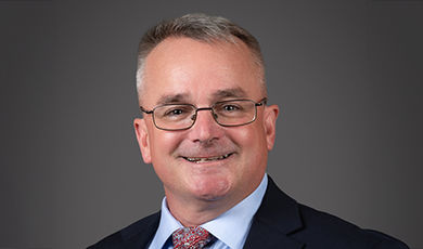 Headshot of Mike Adams in front of a black background