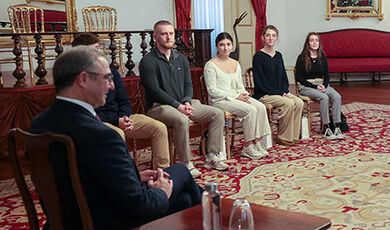 Students sit in chairs listening to the president of the Azores.