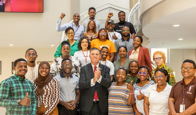 The Mandela fellows stand on steps with President Clark.