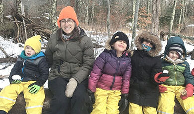 Cristy O'Brien with students sitting in the woods.