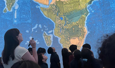 Students and an instructor gaze up at the EarthView globe.