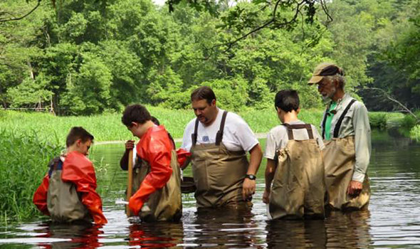 Stormwater steward students in a river