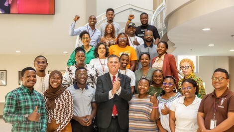 The Mandela fellows stand on steps with President Clark.