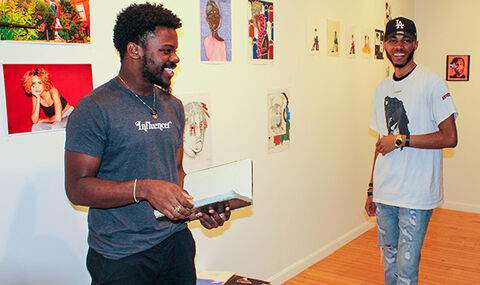 2 students smiling at an art exhibit at the BSU Anderson Gallery