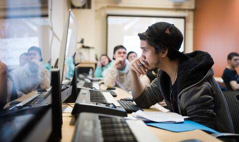 students in a music class sitting at keyboards and looking at computers