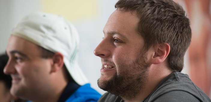 Two male students in class smiling