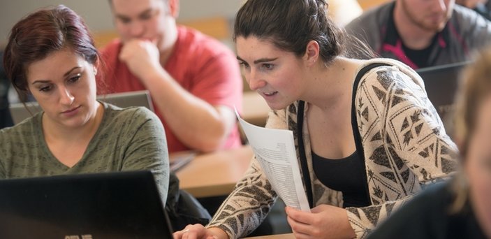 Students working at laptop computers in class