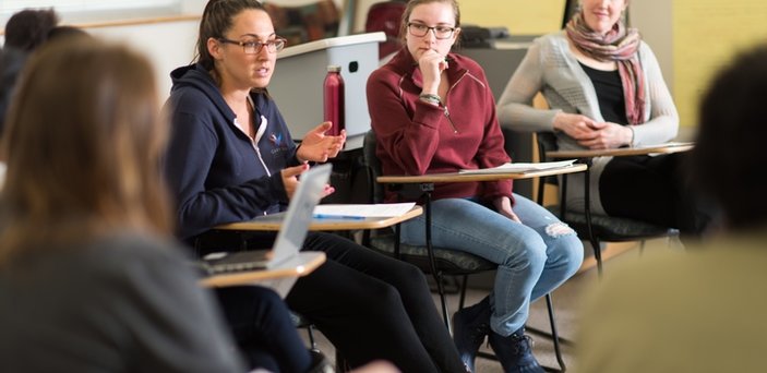 Professor and students sitting in a circle having discussion