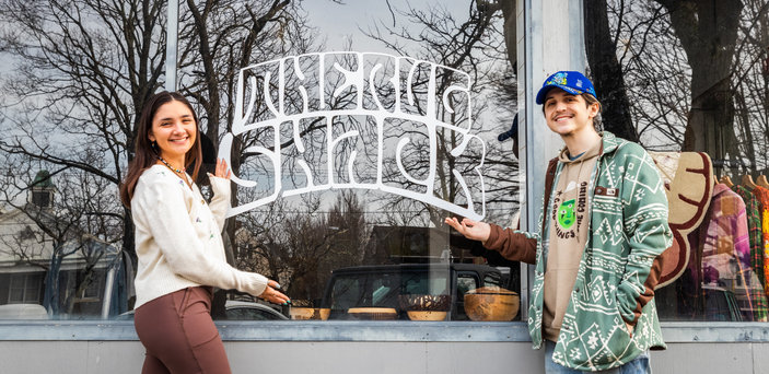 Matt and Megan stand in front of Rug Shack store windwo 